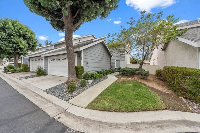 view of home's exterior with driveway, a garage, and fence