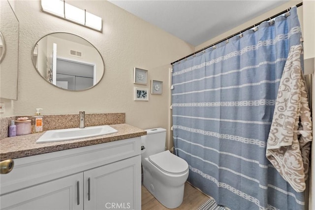 full bathroom featuring visible vents, toilet, a shower with curtain, wood finished floors, and vanity