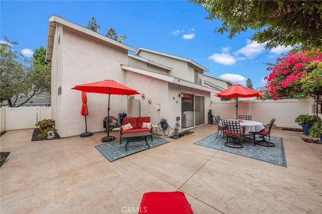 rear view of property with a patio, a fenced backyard, outdoor dining area, an outdoor living space, and stucco siding