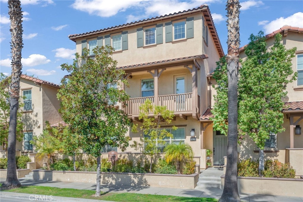 mediterranean / spanish-style house with a tiled roof, a balcony, and stucco siding