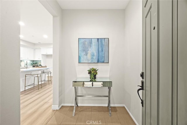 foyer with light wood finished floors and baseboards