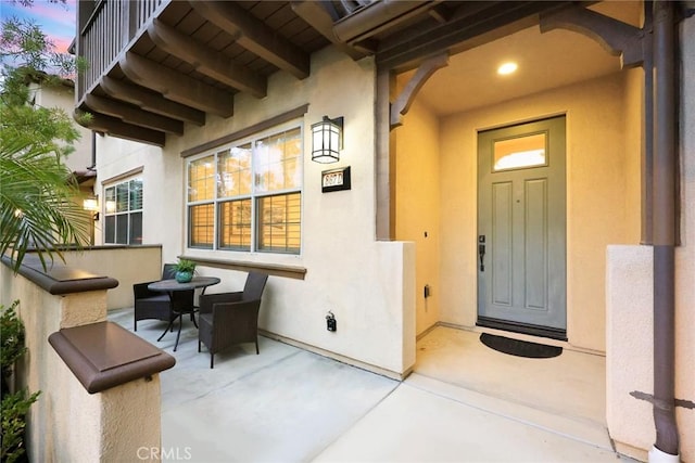 exterior entry at dusk featuring stucco siding