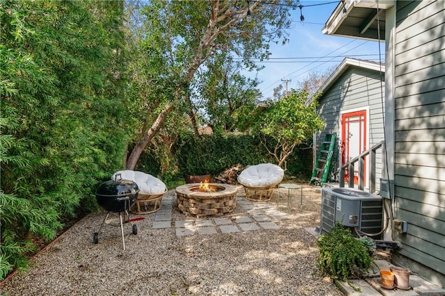 view of patio / terrace with a fire pit, central AC unit, fence, and a grill