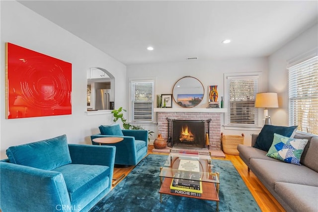 living area with a fireplace, visible vents, wood finished floors, and recessed lighting