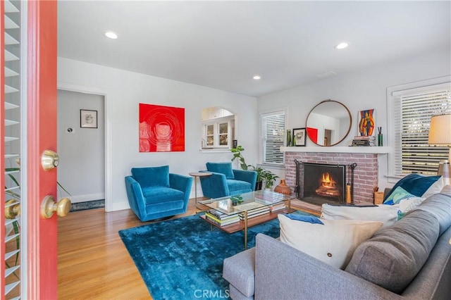 living room with recessed lighting, a fireplace, and wood finished floors