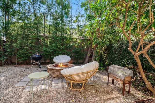 view of patio featuring a fire pit, a grill, and fence