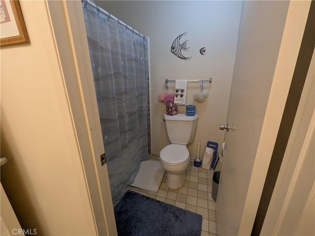 full bath with a shower with curtain, toilet, and tile patterned floors