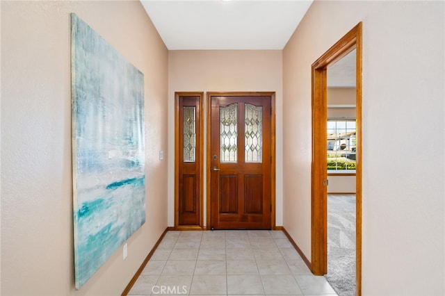 entryway with light tile patterned floors and baseboards