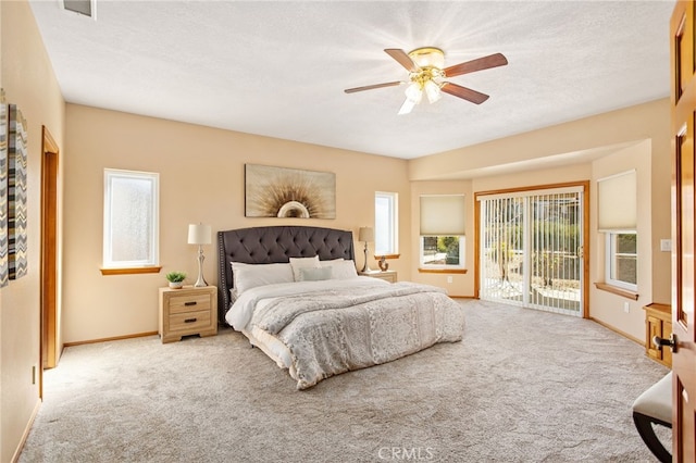 bedroom featuring light carpet, access to outside, a textured ceiling, and baseboards