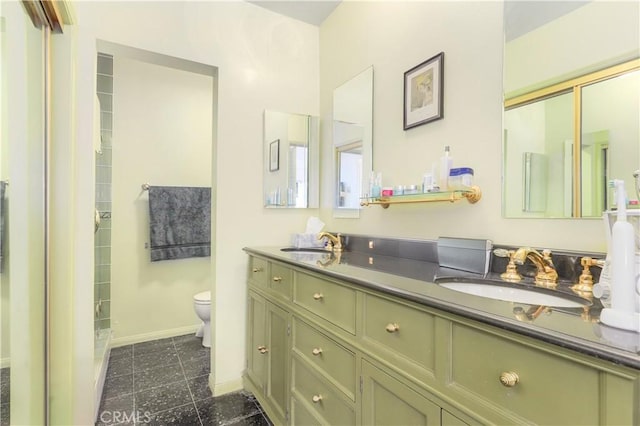 bathroom with toilet, a sink, baseboards, and double vanity