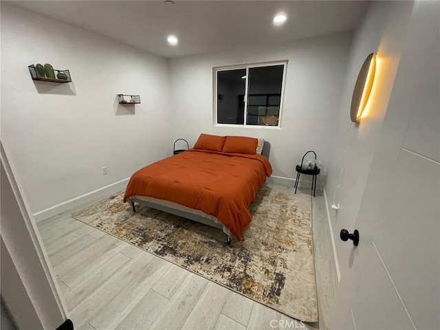 bedroom with baseboards, wood finished floors, and recessed lighting