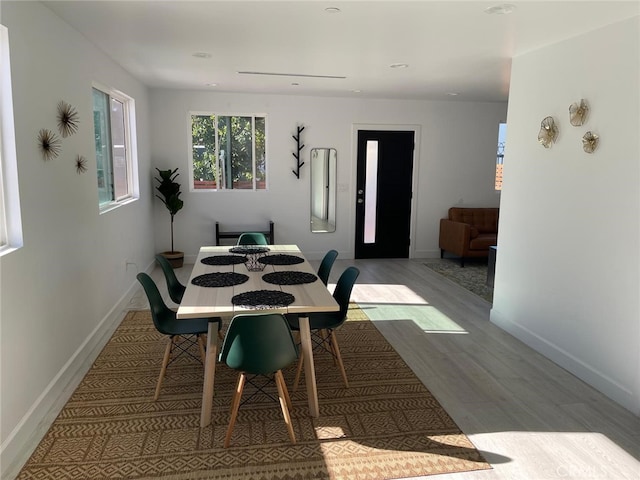 dining area with light wood-type flooring and baseboards