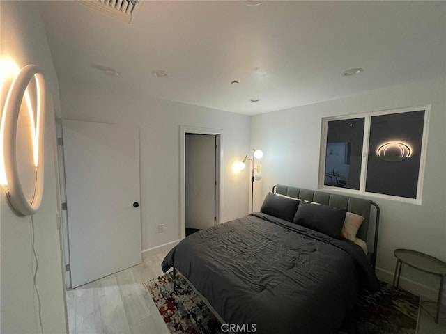 bedroom with light wood-style floors and baseboards