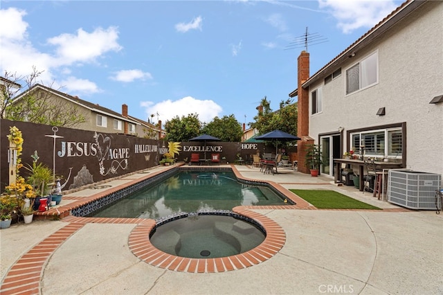 view of swimming pool featuring a pool with connected hot tub, a patio area, a fenced backyard, outdoor dry bar, and central AC