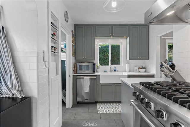 kitchen with a sink, stainless steel appliances, extractor fan, and light countertops