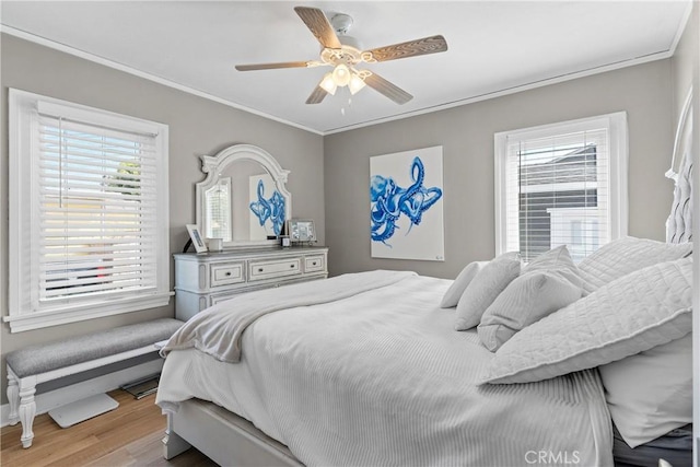 bedroom with ceiling fan, ornamental molding, and light wood-type flooring