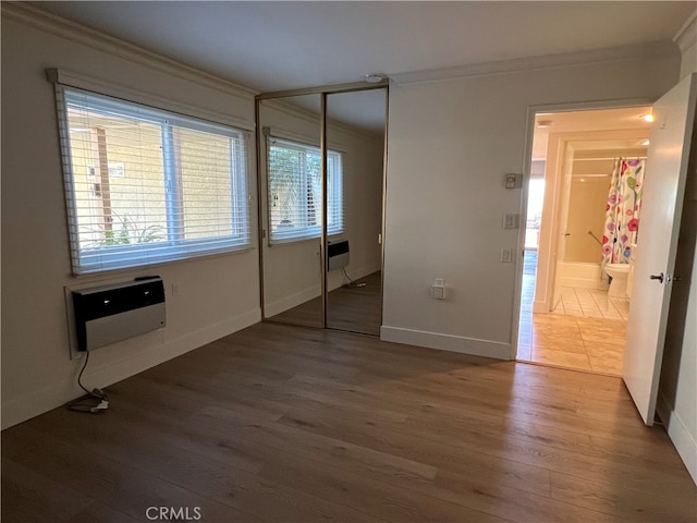 4018 Calle Sonora Este Unit C, Laguna Woods, CA 92637 - unfurnished bedroom featuring ornamental molding, wood finished floors, a closet, baseboards, and a wall mounted air conditioner