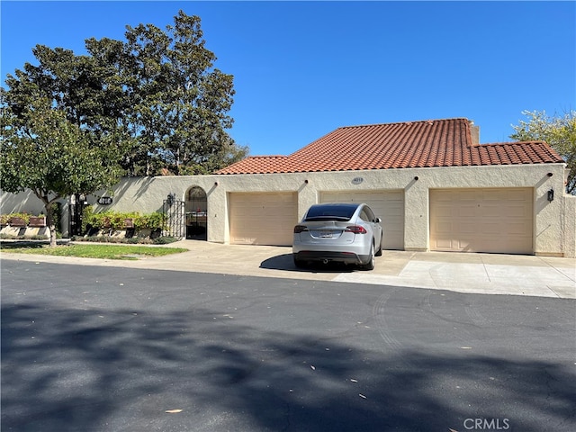 4018 Calle Sonora Este Unit C, Laguna Woods, CA 92637 - view of front of home featuring an attached garage, a tile roof, and stucco siding