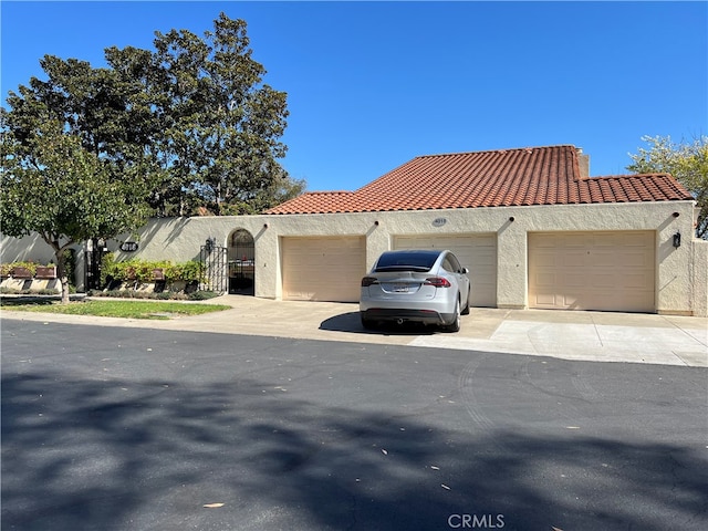 4018 Calle Sonora Este Unit C, Laguna Woods, CA 92637 - view of front facade featuring stucco siding, a tile roof, and an attached garage