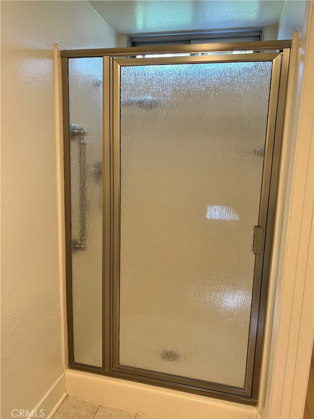 4018 Calle Sonora Este Unit C, Laguna Woods, CA 92637 - bathroom featuring a stall shower, marble finish floors, and baseboards
