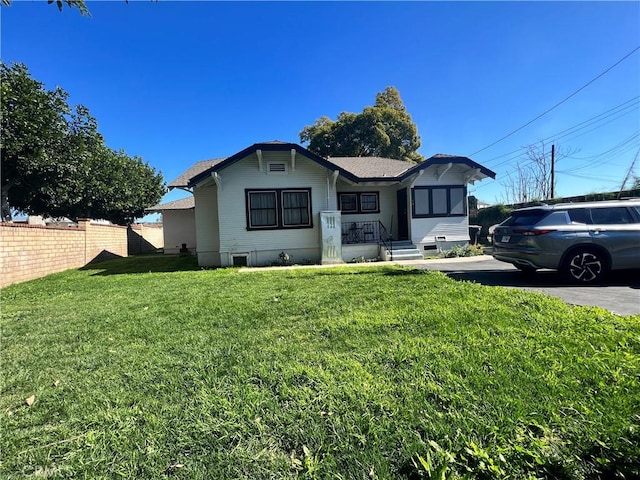 view of front facade with a front yard and fence