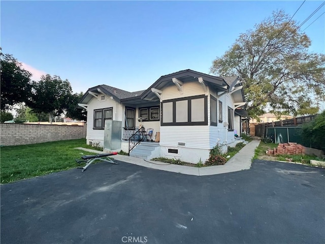 bungalow featuring a yard and fence