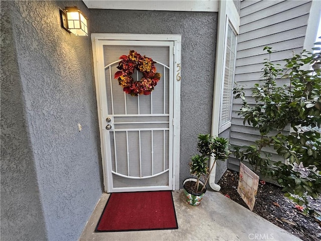 view of exterior entry featuring stucco siding