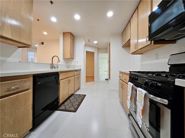 kitchen featuring recessed lighting, light countertops, light brown cabinetry, black appliances, and baseboards