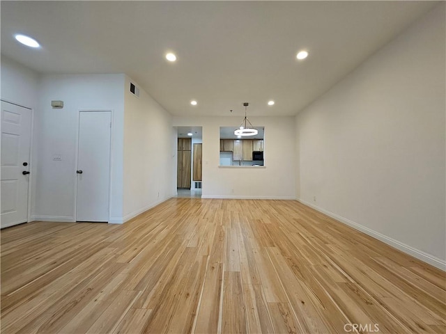 unfurnished living room with recessed lighting, visible vents, light wood-style flooring, and baseboards