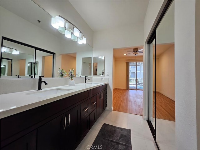 full bath featuring double vanity, tile patterned flooring, a ceiling fan, and a sink