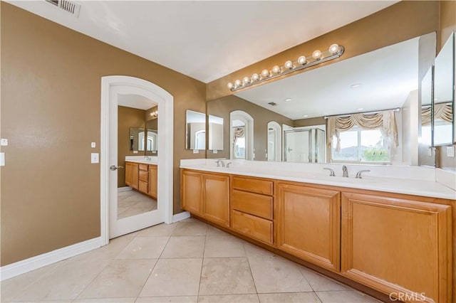 bathroom featuring tile patterned flooring, visible vents, a sink, and double vanity