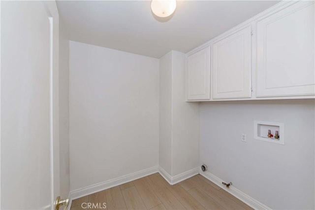 laundry room featuring hookup for a washing machine, cabinet space, baseboards, and light wood-style floors