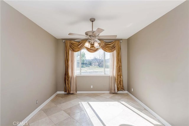 unfurnished room featuring a ceiling fan, baseboards, and light tile patterned floors