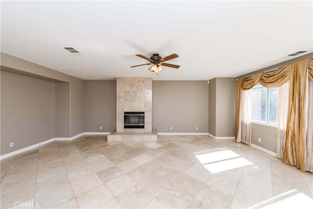 unfurnished living room with ceiling fan, a fireplace, visible vents, and baseboards