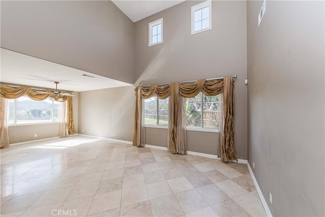 unfurnished living room with visible vents, a high ceiling, baseboards, and light tile patterned flooring