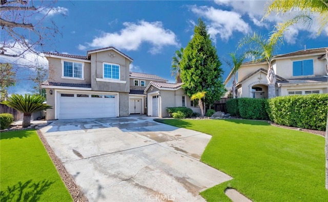 mediterranean / spanish house with a front yard, driveway, an attached garage, and stucco siding