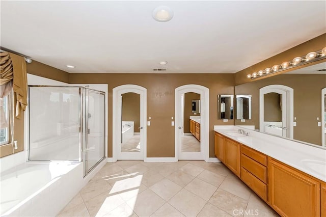 full bathroom featuring double vanity, a stall shower, visible vents, and a sink