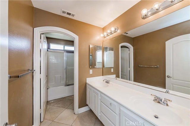 full bathroom with tile patterned flooring, visible vents, combined bath / shower with glass door, and a sink