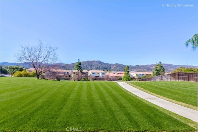 view of yard featuring fence and a mountain view