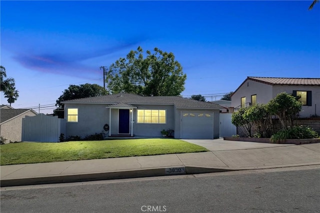view of front facade featuring driveway, fence, an attached garage, a front yard, and stucco siding