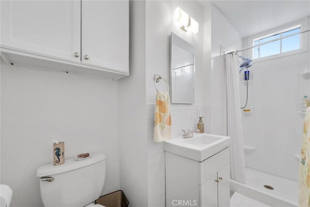 full bath with vanity, toilet, and a shower stall
