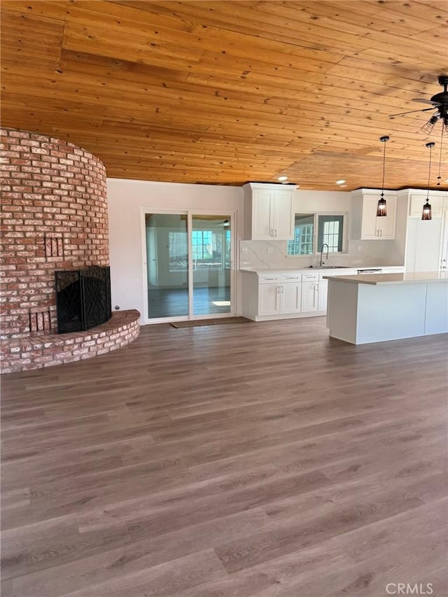 kitchen featuring wooden ceiling, white cabinets, open floor plan, light countertops, and decorative light fixtures