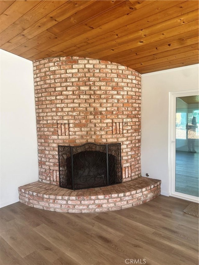 interior details with wood ceiling, a fireplace, and wood finished floors