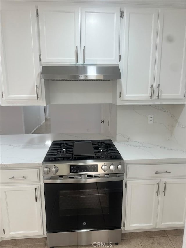 kitchen with stainless steel range with gas stovetop, under cabinet range hood, and white cabinetry