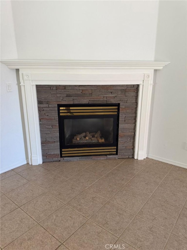 interior details featuring baseboards and a stone fireplace