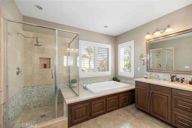 bathroom with a garden tub, vanity, and a stall shower