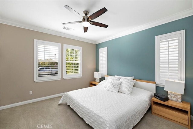 bedroom with ceiling fan, light carpet, visible vents, baseboards, and crown molding