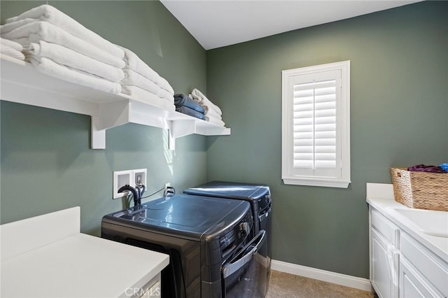 washroom with washing machine and clothes dryer, cabinet space, and baseboards