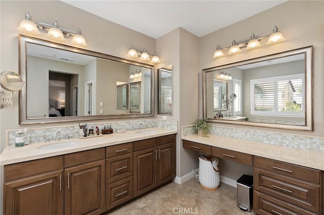 full bath with double vanity, ensuite bath, decorative backsplash, and a sink