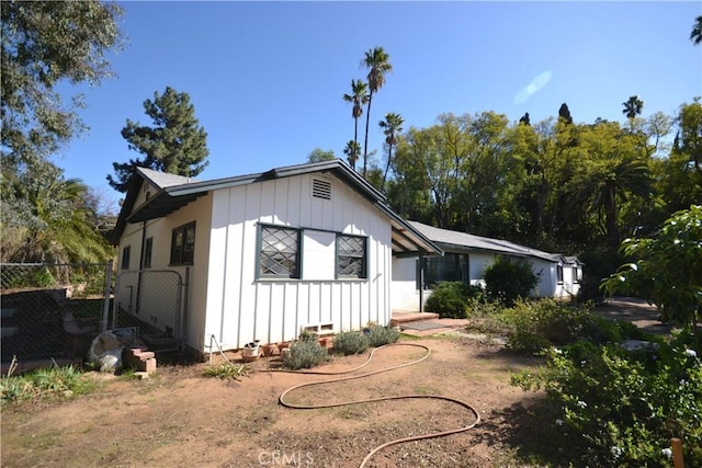 view of front facade featuring board and batten siding and fence